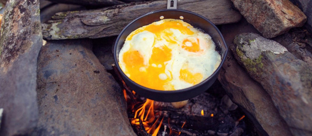 Fry some eggs in a skillet for a nice and easy camping meal.